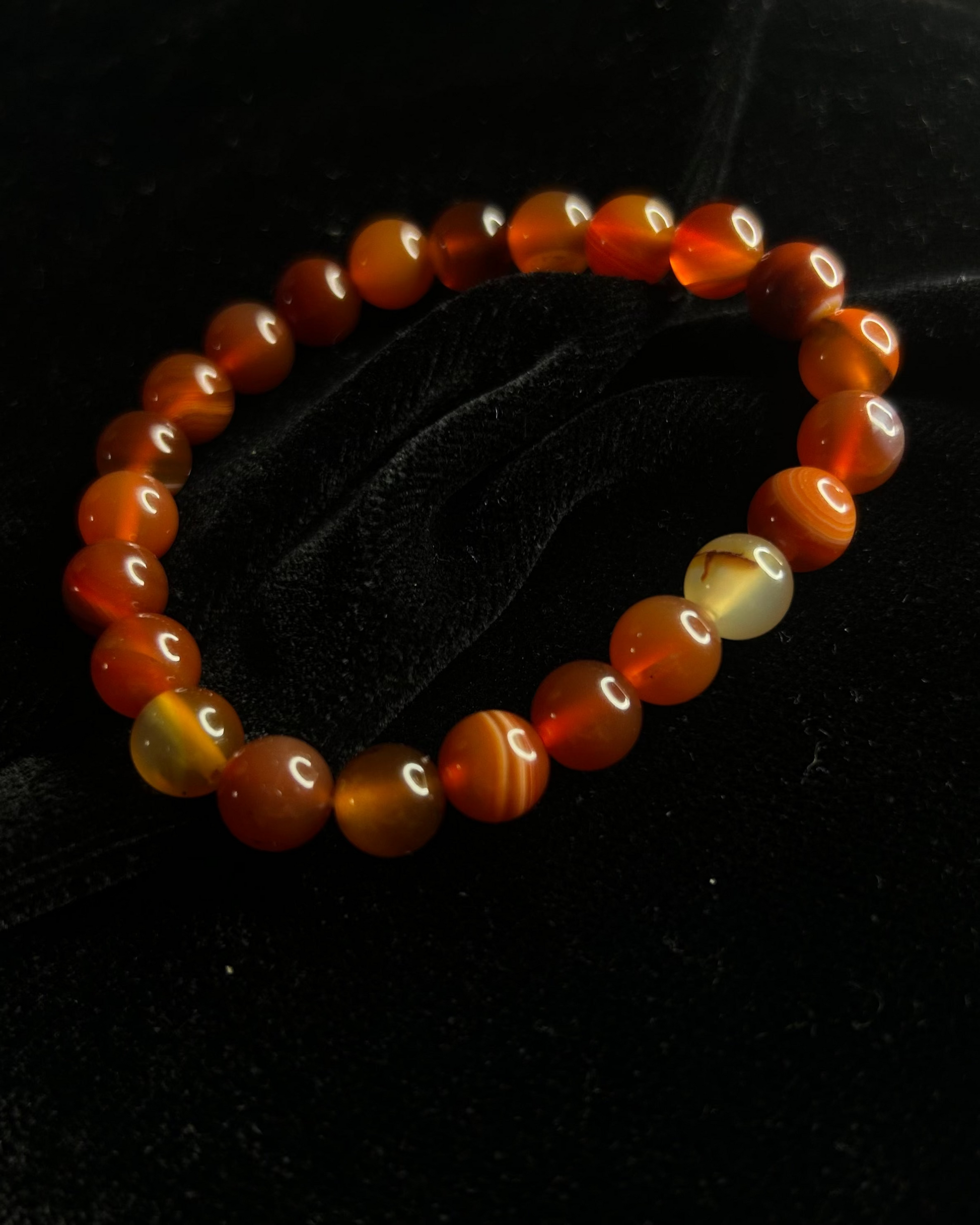 Beaded bracelet with orange and yellow beads on a black background