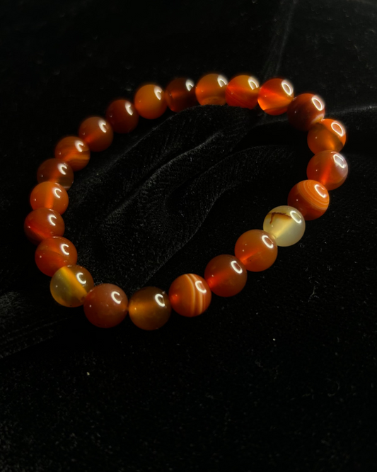 Beaded bracelet with orange and yellow beads on a black background