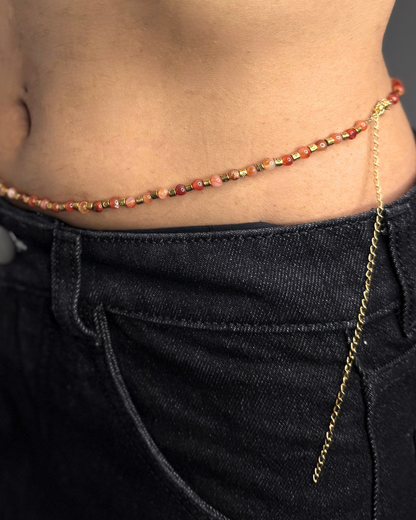 Close-up of a beaded waist chain worn with dark jeans.
